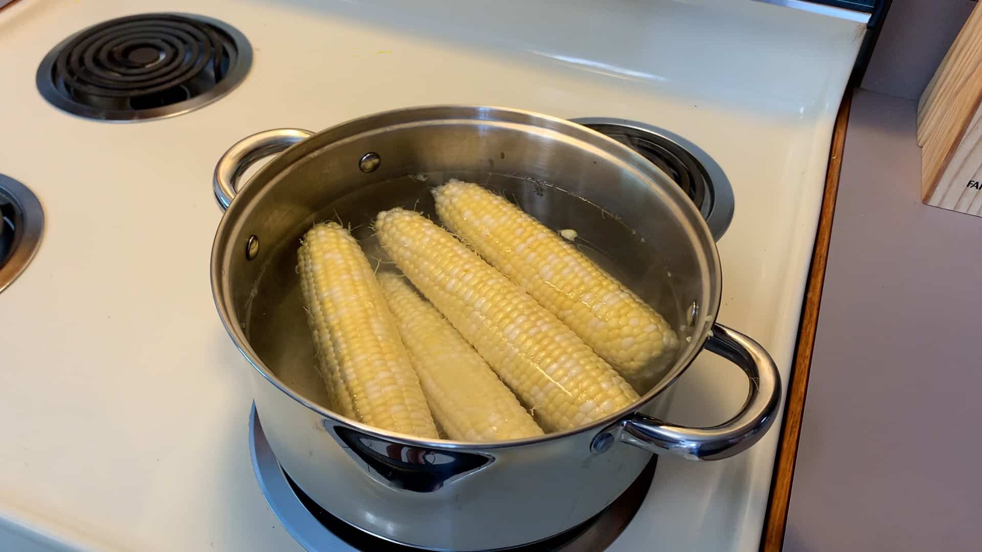 ears of corn boiling on the stove