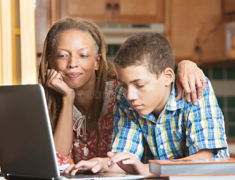 mom helping son with computer work