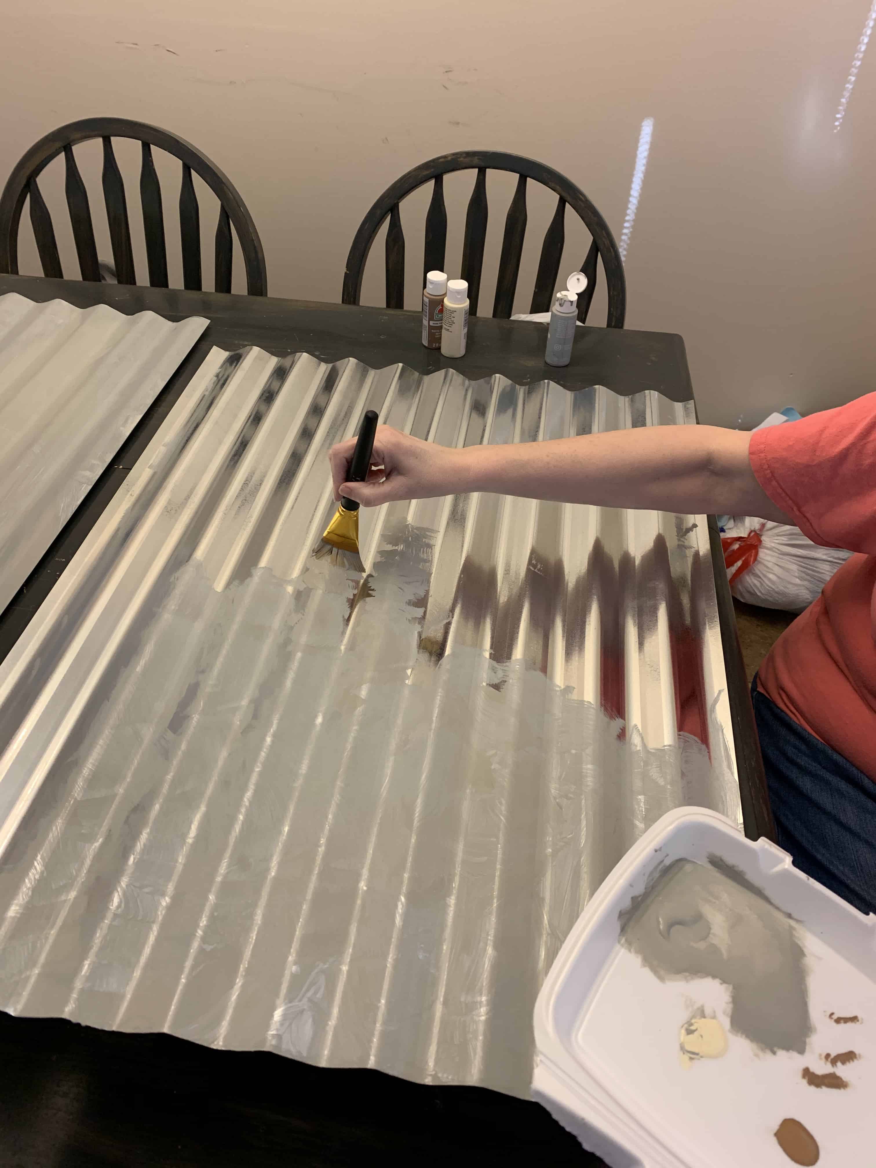 woman painting tin