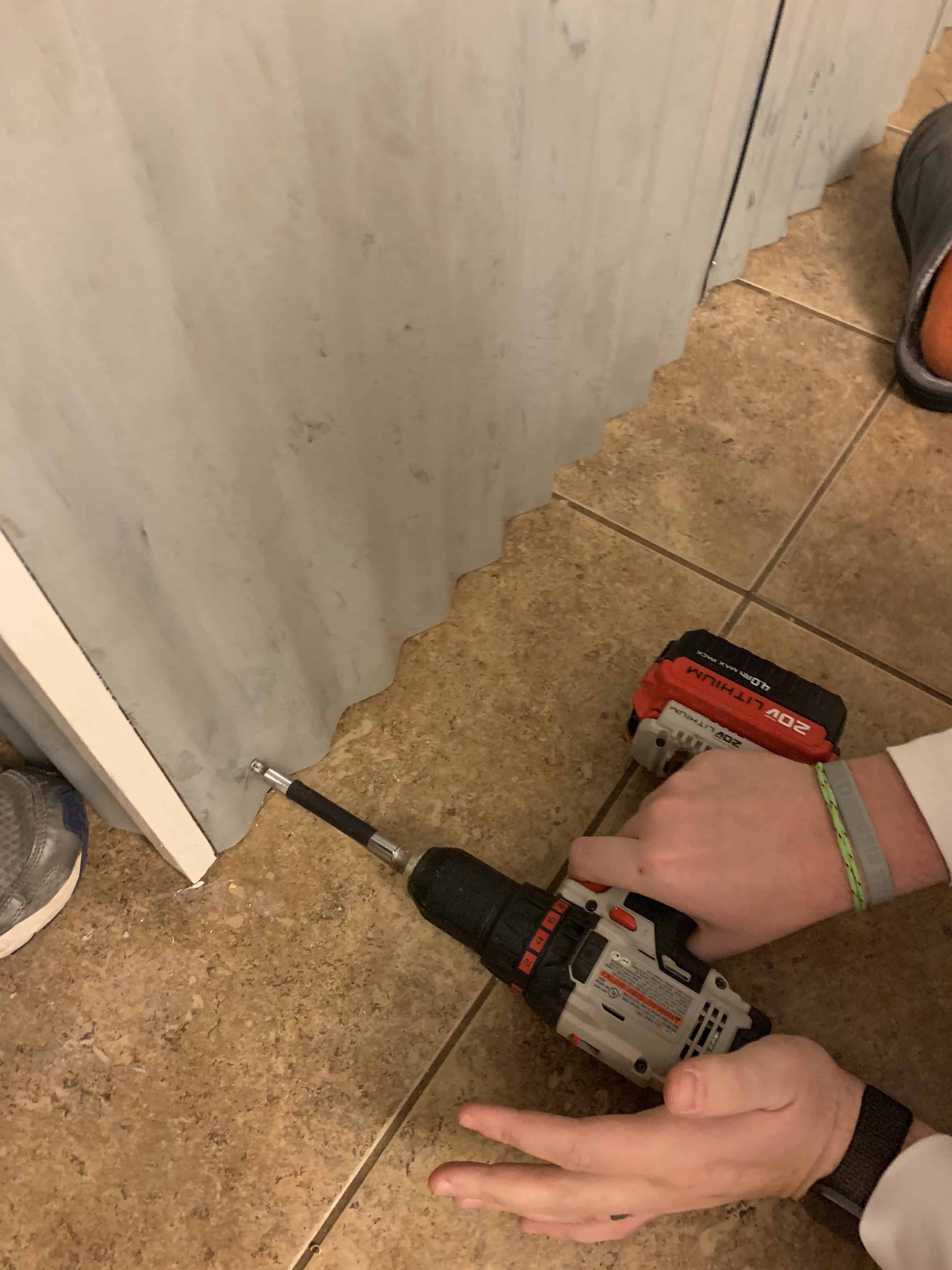 man screwing screw into tin