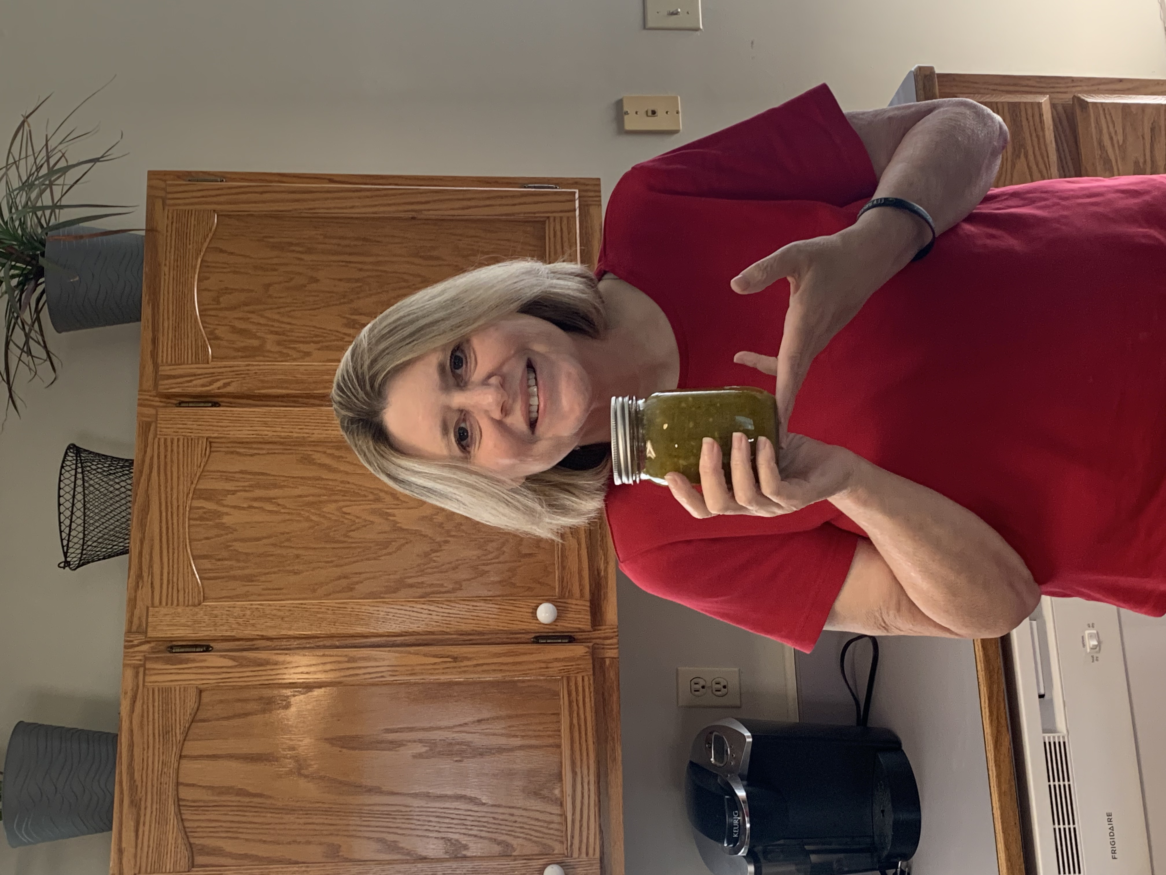 woman holding jar of green tomato ketchup relish