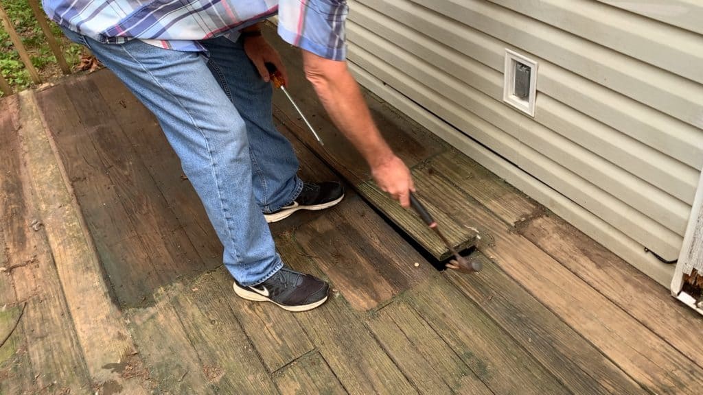 man pulling up planks